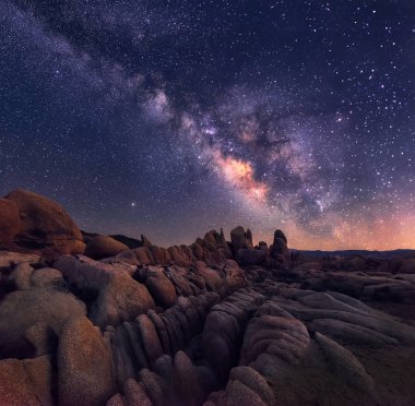 The Milky Way rising over the rugged and rocky terrain of joshua Tree national park is an awe inspiring sight clipart