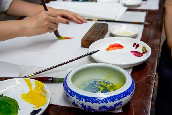 An artist painter is creating traditional Chinese paintings