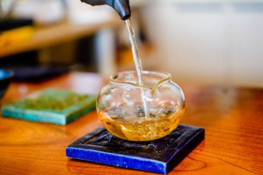 Çin çay seti, bir insan çay fincanına çay dolduruyor, çay içiyor.