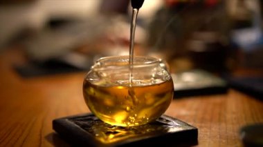 Bir adam çay içiyor, çaydanlığa çay dolduruyor.