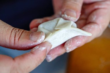 Geleneksel Çin yemekleri yapan bir kişi var.