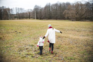 Genç Anne sonbahar alandaki küçük kızı ile yürüme