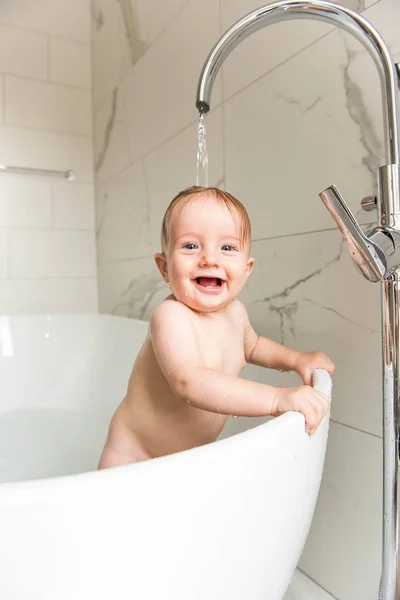 微笑的婴儿男孩站立在沐浴在流动的水之下 — 图库照片