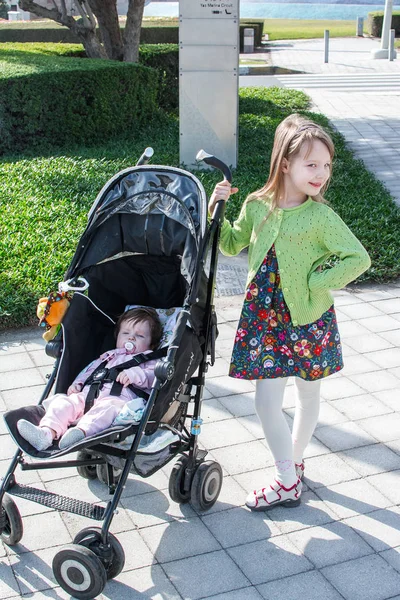 Kislány Sétál Kishúgával Egy Babakocsiban — Stock Fotó