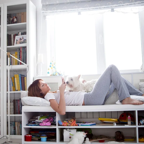 Girl with a phone and a dog