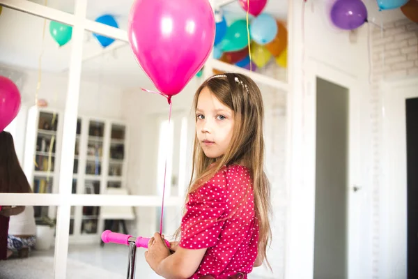 Little girl plays on a holiday with balloons
