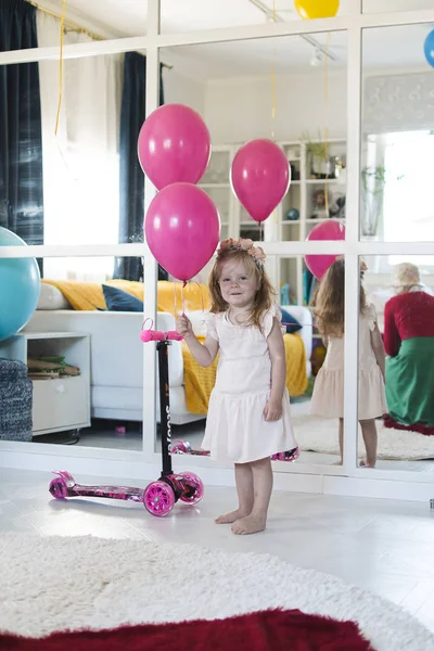 Little girl plays on a holiday with balloons