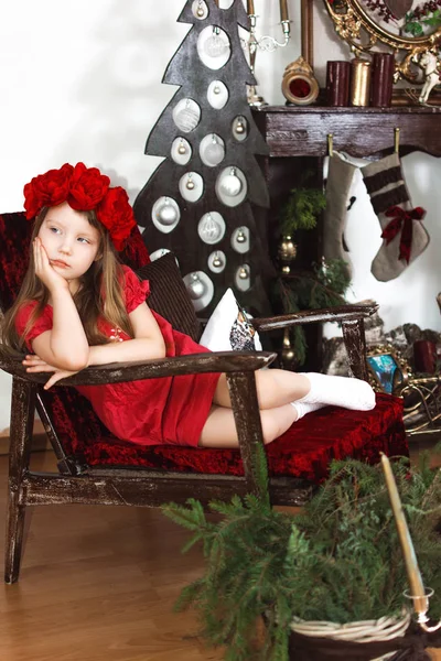 Menina Vestido Vermelho Chapéu Sentado Cadeira Quarto Decorado Natal — Fotografia de Stock