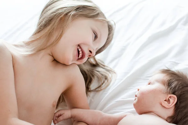 Little Girl Playing Her Newborn Sister Bed — Stock Photo, Image