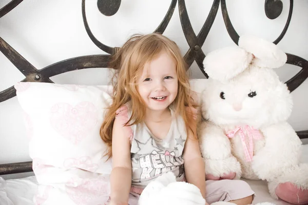 Menina Loira Bonita Feliz Sorrindo Sentado Com Coelho Brinquedo Cama — Fotografia de Stock