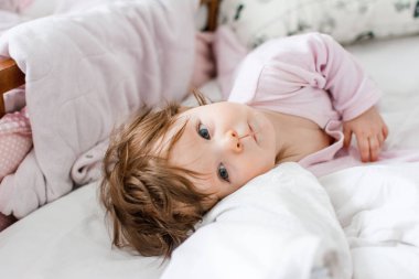 kreşte keten kapak üzerinde yatan sevimli küçük kız