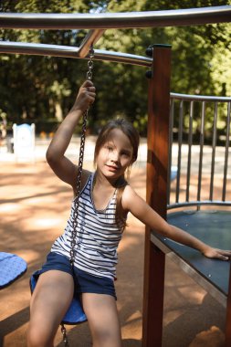 güneşli yaz gününde oyun alanında tırmanırken eğlenceli sevimli kız 