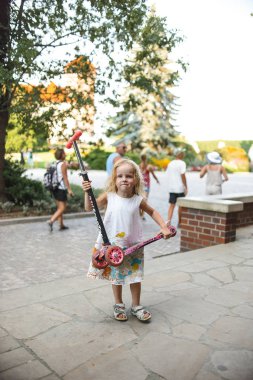 Duvarlar boyunca elbiseli küçük kız