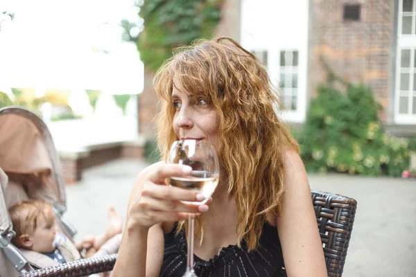 Vrouw Met Golvend Haar Drinken Witte Wijn Uit Glas Zittend — Stockfoto
