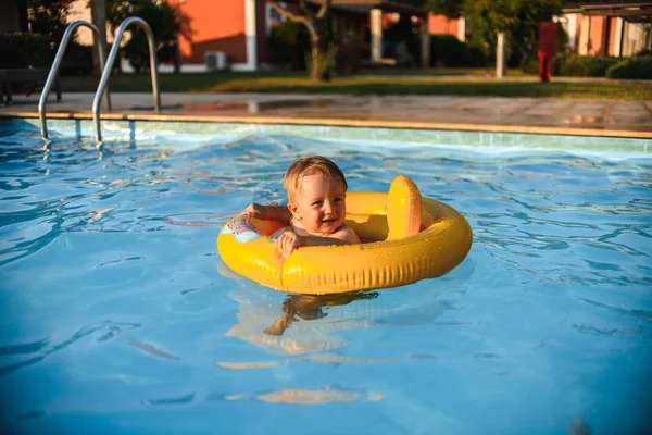晴れた日にプールで泳ぐインフレータブルサークルの小さな男の子 — ストック写真