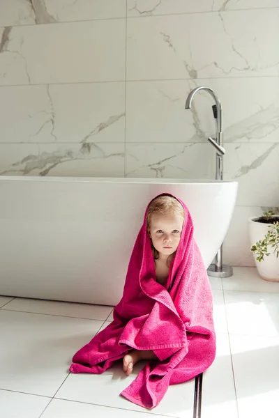 金发女孩裹在粉红色的毛巾坐在附近白色 Buthtube — 图库照片