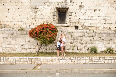 Kale duvarında kızları olan bir anne.
