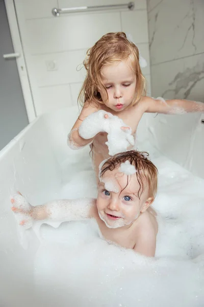 Küçük kardeşi ve kız kardeşi birlikte eğlenceli ve çekici banyo ışık banyoya sahip  
