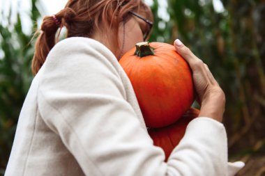 Cadılar Bayramı kadınları bir mısır tarlasında balkabağıyla yürüyor