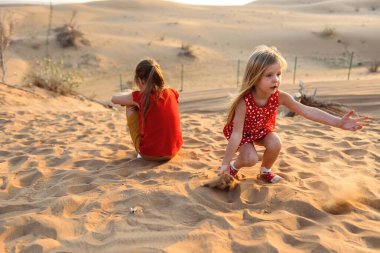 Emirliğin kumlarında oynayan çocuklar