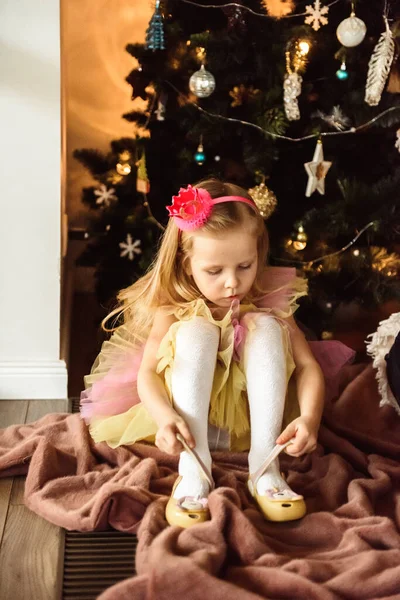 Κοριτσάκι Ντύνεται Κοντά Στο Χριστουγεννιάτικο Δέντρο — Φωτογραφία Αρχείου