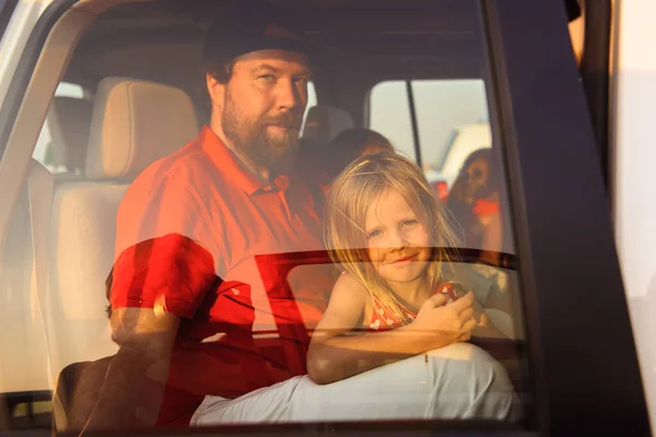 Dad with children in the car at sunset