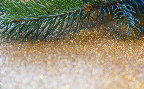 Tatil, kış ve kutlama kavramı. Noel ve yeni yıl kartı ile Noel ağacı çam dalları parlak altın arka plan üzerinde.