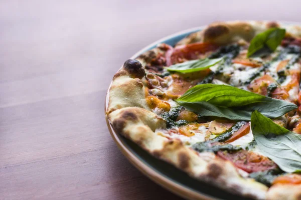 Ahşap masa arka plan, üstten görünüm üzerinde pizza Margarita. Pizza Margarita domates, taze fesleğen, Mozzarella peyniri, biber ve baharat ile kapatın. İtalyan Pizza dilimlenmiş. Pizza Margherita veya Margarita. 