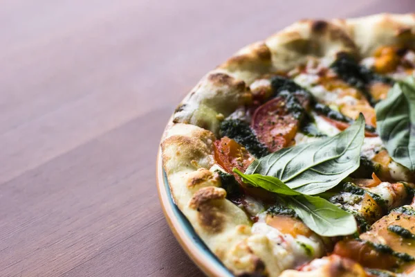 Ahşap masa arka plan, üstten görünüm üzerinde pizza Margarita. Pizza Margarita domates, taze fesleğen, Mozzarella peyniri, biber ve baharat ile kapatın. İtalyan Pizza dilimlenmiş. Pizza Margherita veya Margarita. 