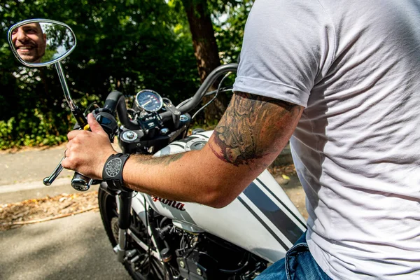 Kyiv 'deki Geon Daytona motosikletinde dövmeli, sakallı ve bilezikli genç yakışıklı bir adam.