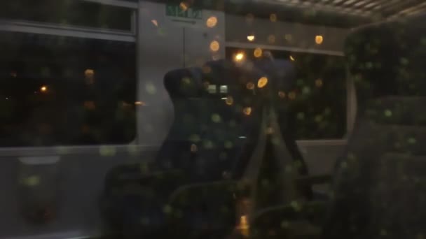 Wazige stadslichten reflectie op het trein venster 's nachts. — Stockvideo