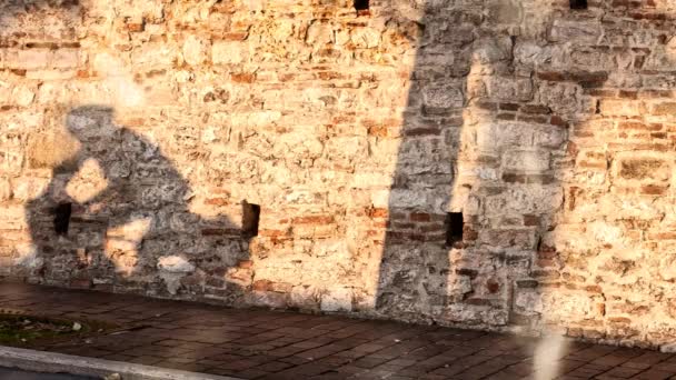 Cyclist shadow projected on an ancient city wall. Cinemagraph — Stock Video