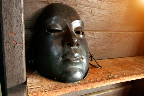 Black plastic Mask on wooden background