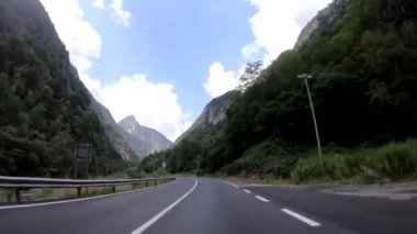 İsviçre'deki dağlar arasında virajlı bir yolda sürüş 