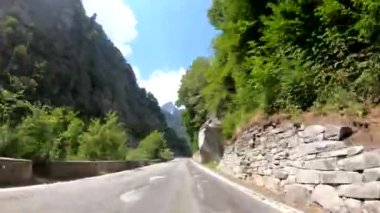 İsviçre'deki dağlar arasında virajlı bir yolda sürüş 