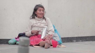Yaşlı bir Kızılderili kadın sokakta para talebinde de Bogota