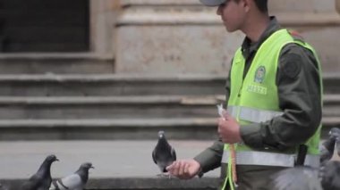 Genç Kolombiyalı polis güvercin besleme