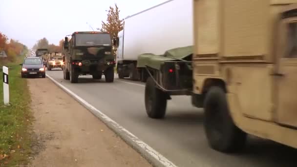 Convoy de vehículos militares que pasan por una carretera Metraje De Stock