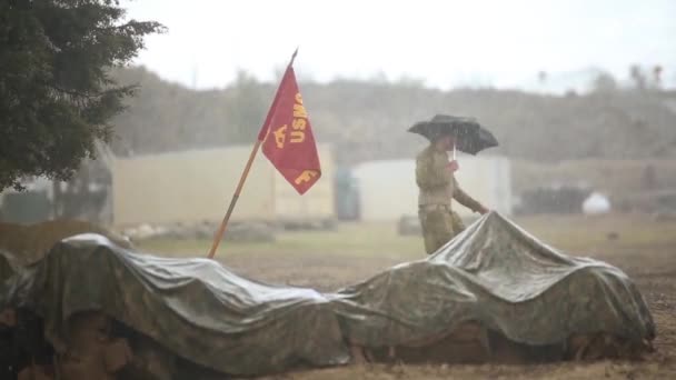 Soldados cubriendo la lluvia abundante llevando impermeables camuflados — Vídeo de stock