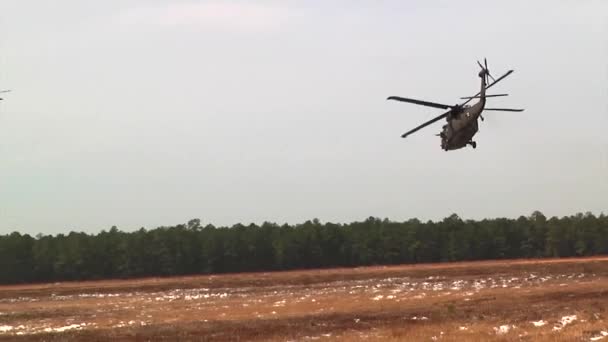 Dos Sikorsky UH-60 Black Hawks volando sobre un campamento cubierto de nieve — Vídeo de stock