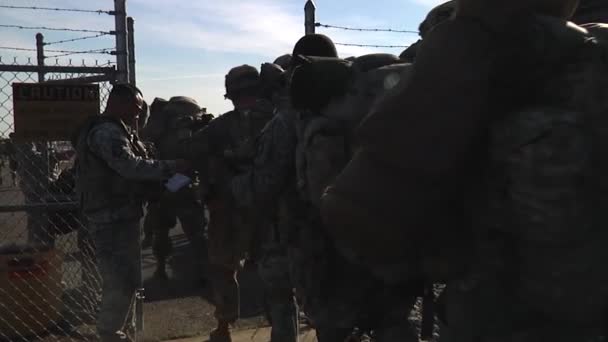 Soldados llevando paquetes y portando armas — Vídeo de stock