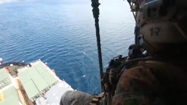 Soldiers dismount a helicopter onto a ship — Stock Video