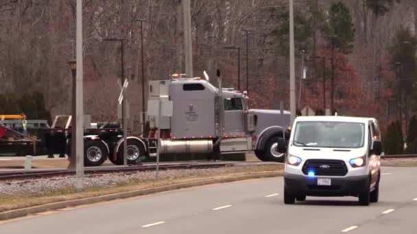 Veicoli che scortano un rimorchio a pianale che trasportano una struttura Clip Video