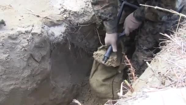 Soldat gräbt einen Schützengraben und feilt an einem Sandsack Videoclip
