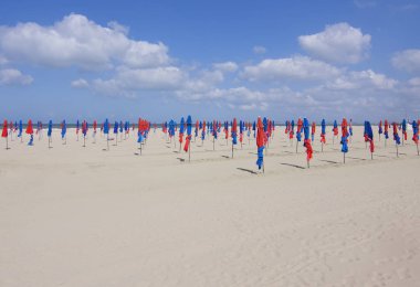 Deauville plajında ünlü renkli mavi ve kırmızı şemsiyeler, Normandiya, Fransa. 