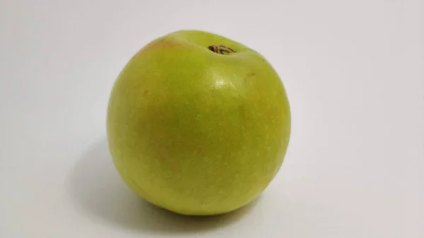 Зеленое сладкое яблоко крупным планом на белом фоне — стоковое фото