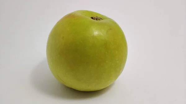 Зеленое сладкое яблоко крупным планом на белом фоне — стоковое фото