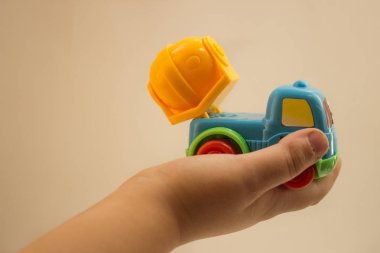 bir oyuncak araba hafif bir arka plan üzerinde tutan çocuk