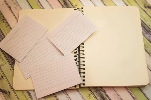 Defter ve kağıt renkli arka plan üzerinde