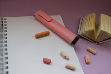 Not defteri ve pembe marker mor zemin üzerine
